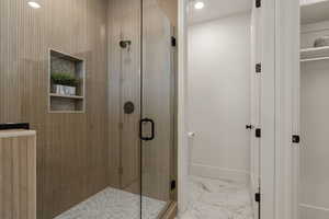 Full bathroom with light marble finish floors, a stall shower, and recessed lighting