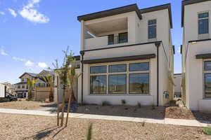 View of front of house with a balcony and stucco siding