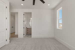 Unfurnished bedroom featuring light colored carpet, recessed lighting, ensuite bathroom, and a ceiling fan