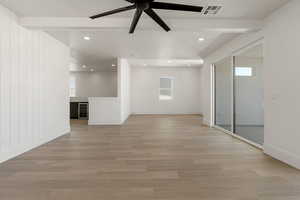 Spare room featuring beam ceiling, light wood finished floors, wine cooler, ceiling fan, and recessed lighting