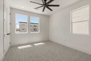Unfurnished room featuring light carpet, ceiling fan, and recessed lighting