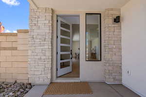 Property entrance featuring stucco siding and stone siding