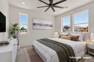 Bedroom with light colored carpet, ceiling fan, and recessed lighting