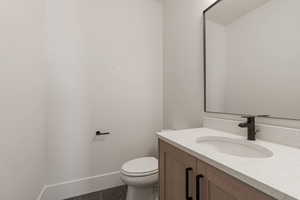 Half bathroom featuring vanity and toilet