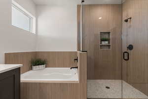 Bathroom featuring a garden tub, a stall shower, and vanity