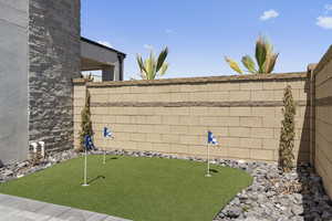 Fenced backyard with a putting green