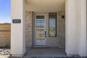 Doorway to property with stone siding and stucco siding