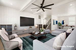 Living room featuring beamed ceiling, wood finished floors, ceiling fan, stairs, and recessed lighting