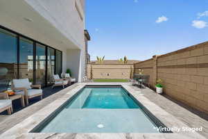 View of swimming pool with a fenced backyard and a patio