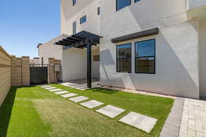 Rear view of property with a fenced backyard, stucco siding, a pergola, a patio area, and a gate