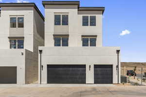 Contemporary home featuring stucco siding, a garage, and concrete driveway