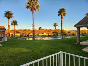 View of green lawn with a residential view and a water view