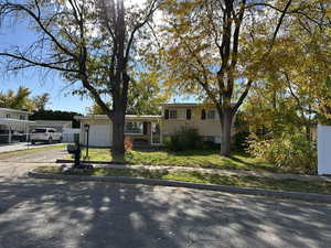 Tri-level home with driveway, a front yard, and an attached garage