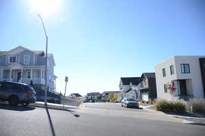 View of asphalt street with a residential view, curbs, and sidewalks