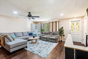 Living area featuring dark wood-style flooring, a textured ceiling, crown molding, recessed lighting, and ceiling fan
