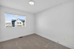 Carpeted spare room with baseboards