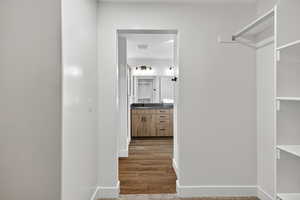 Spacious closet featuring light wood finished floors and a sink