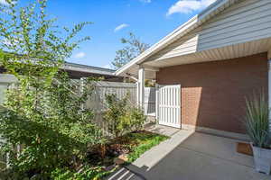 Property entrance featuring a gate and brick siding