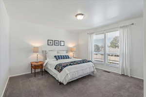 Bedroom featuring carpet and baseboards