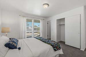 Carpeted bedroom with baseboards and a closet