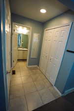 Hallway with light tile patterned floors and recessed lighting