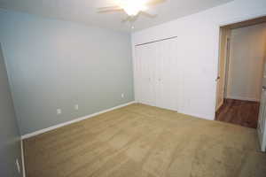Unfurnished bedroom with carpet, ceiling fan, and a closet
