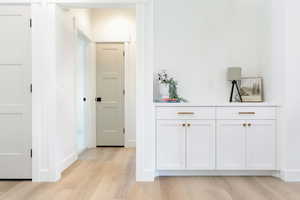 Hall featuring light wood-style floors from kitchen to the other 2 bedrooms