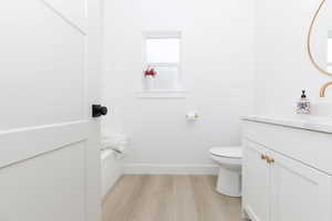 Bathroom featuring vanity, light wood-style floors, and a tub