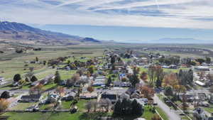 Aerial view of property and surrounding area with nearby suburban area and a mountain backdrop