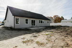 Rear view of property featuring a patio area and roof with shingles