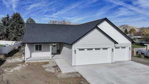 View of front of home with a garage, concrete driveway, roof with shingles, and a mountain view