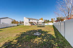 Back of house featuring stairway, a fenced backyard, and a trampoline