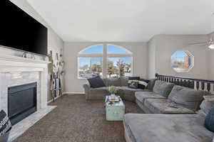 Carpeted living room featuring a fireplace and baseboards