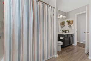Bathroom with vanity, curtained shower, and light wood finished floors