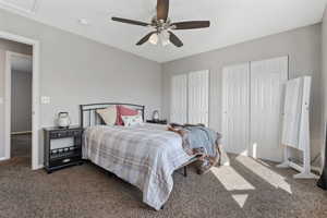 Bedroom featuring carpet, two closets, and a ceiling fan