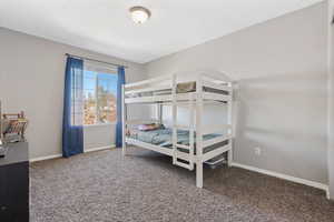 Bedroom featuring carpet and baseboards