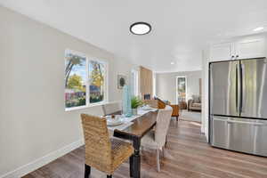Dining area with light wood finished floors and recessed lighting