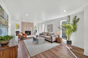 Living area featuring wood finished floors, a fireplace, and recessed lighting