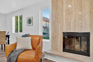 Sitting room featuring a glass covered fireplace and wood finished floors