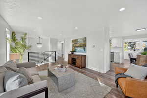 Living area with wood finished floors, recessed lighting, and a textured ceiling