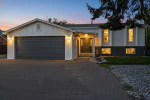 View of front facade featuring driveway, a garage, and board and batten siding