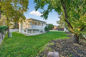Rear view of house featuring a sunroom and a fenced backyard
