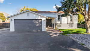 View of front of home with driveway, brick siding, board and batten siding, and an attached garage