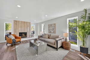 Living area with recessed lighting, wood finished floors, a large fireplace, and a textured ceiling