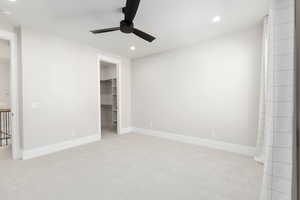 Unfurnished bedroom featuring light carpet, recessed lighting, a ceiling fan, and a spacious closet
