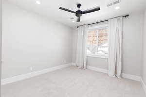 Empty room with light carpet, a ceiling fan, and recessed lighting