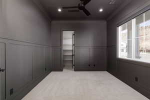 Spare room featuring a decorative wall, ceiling fan, light carpet, a wainscoted wall, and recessed lighting