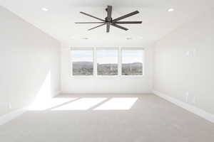 Empty room with light colored carpet, ceiling fan, recessed lighting, and a mountain view