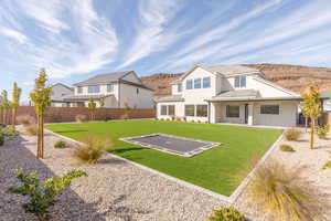 Rear view of house featuring a mountain view, a patio, a fenced backyard, and stucco siding