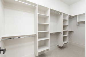 Walk in closet featuring light colored carpet